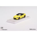 a yellow toy car on a white surface