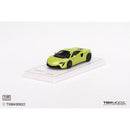 a green toy car on a white surface