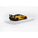 a yellow toy car on a white surface